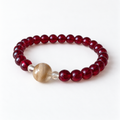 Burgundy beaded bracelet with a rounded clear resin bead holding light pet fur and two clear spacer beads on a white background.